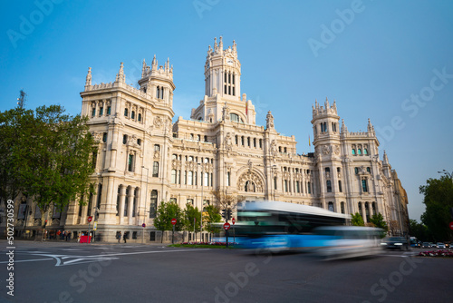 Cibeles building and cars traffic at Plaza de Cibeles in Madrid on a beautiful spring day, Spain