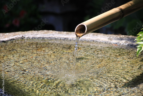 竹を使った樋を通して水が注がれている蹲