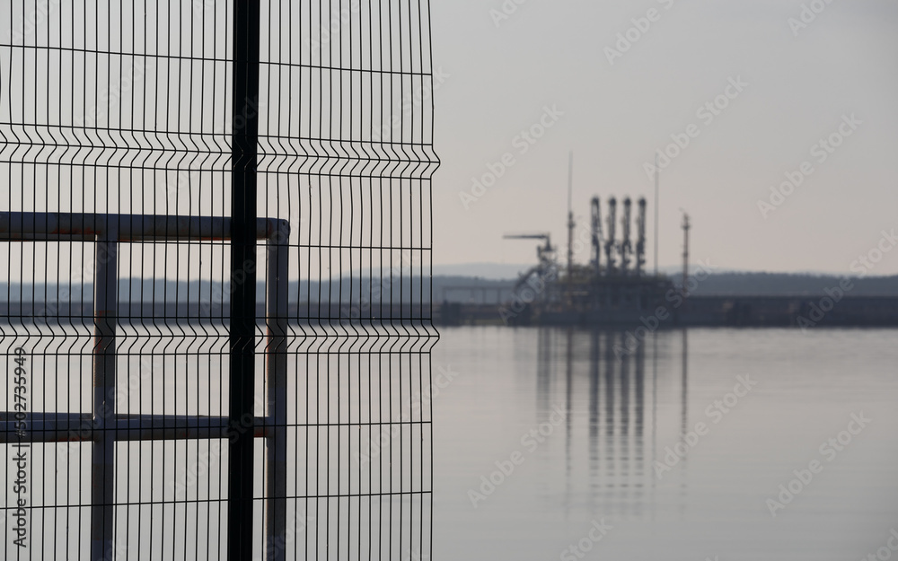 SEAPORT - Fences on breakwater with LNG terminal in the background
SEAPORT - Fences on breakwater with LNG terminal in the background