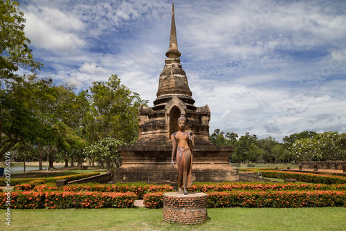 Fototapeta Walking Buddha and Minor Chedi at Wat Sa Si, Sukhothai, Thailand