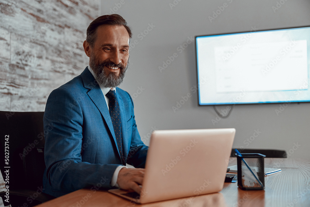 Happy busy man typing on laptop in his cabinet in the office, copy space Happy busy man typing on laptop in his cabinet in the office, copy space