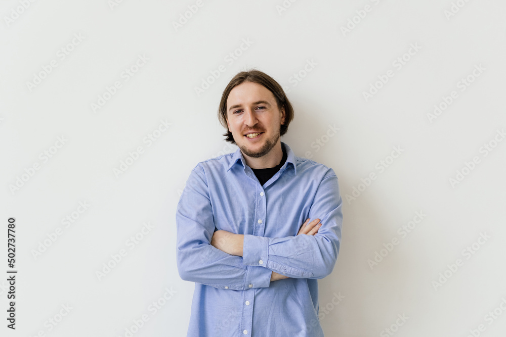 Smiling handsome man standing with crossed arms isolated on gray background Smiling handsome man standing with crossed arms isolated on gray background