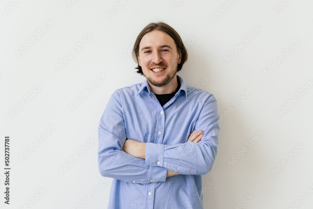 Portrait of smiling handsome man standing with crossed arms isolated on white background Portrait of smiling handsome man standing with crossed arms isolated on white background