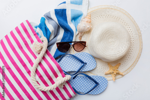 beach accessories flat lay top view on colored background Summer travel concept. Bag with starfish and sea shell. Top view