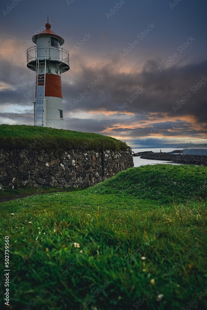 Old lighthouse against incredible sunset sky in Old Town of Torshavn, capital of the Faroe Islands, Denmark, Northern Europe