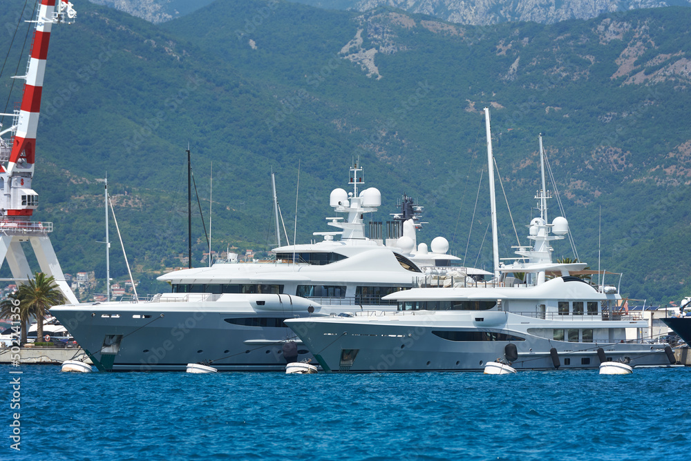 Two luxury white yachts moored in the port