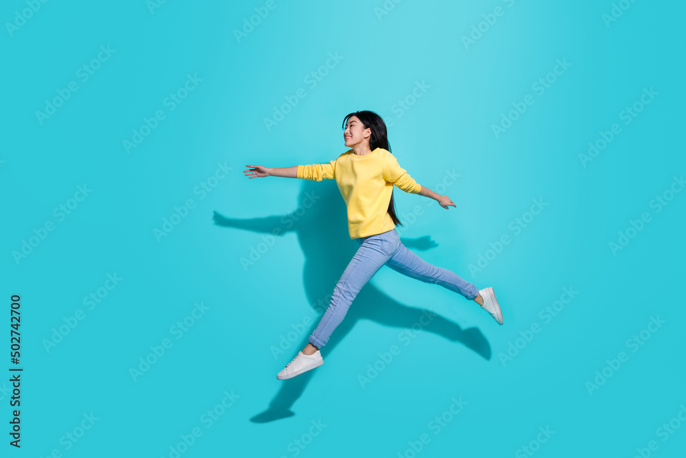 Full length photo of sweet cute lady dressed yellow sweater jumping running empty space isolated turquoise color background