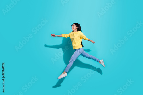 Fototapeta Naklejka Na Ścianę i Meble -  Full length photo of sweet cute lady dressed yellow sweater jumping running empty space isolated turquoise color background