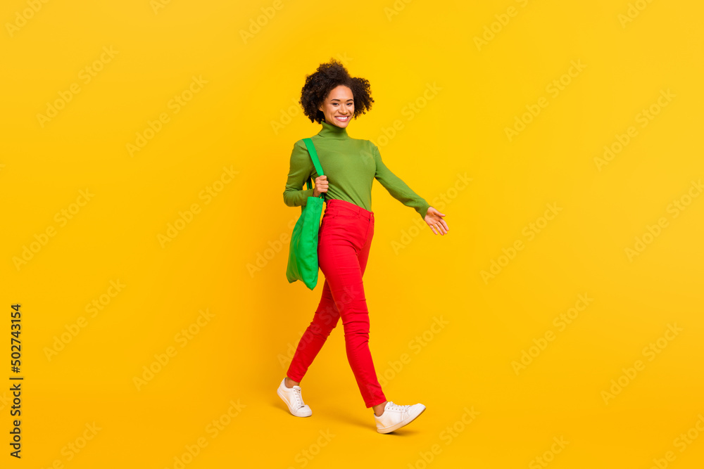 Full size profile side photo of young lady go shop mall grocery discount isolated over yellow color background