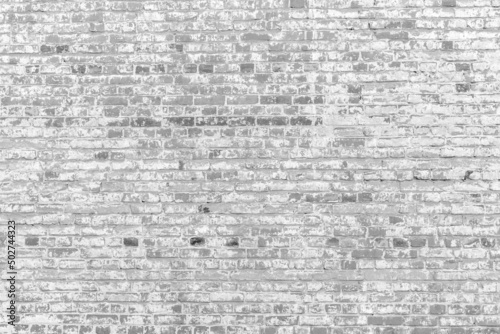 Old white brick wall. Peeling white paint on a white wall.