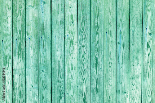 Vintage fence of old wooden boards. Texture of an aging wooden surface. Beautiful wooden background.