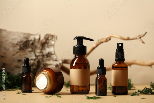 Fotobehang Set of amber glass cosmetic bottles with bark of birch, wood branch, green moss