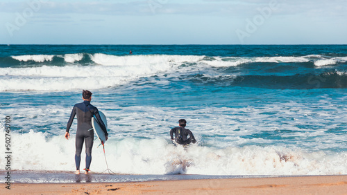 Surfers entering in the sea at Porto Paglia near Cagliari at summer photo