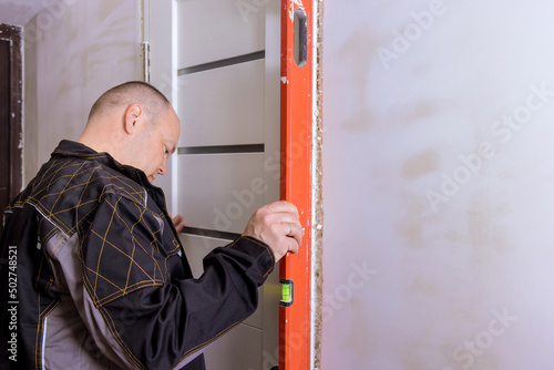 Master checks level correctness installation door with renovation apartment