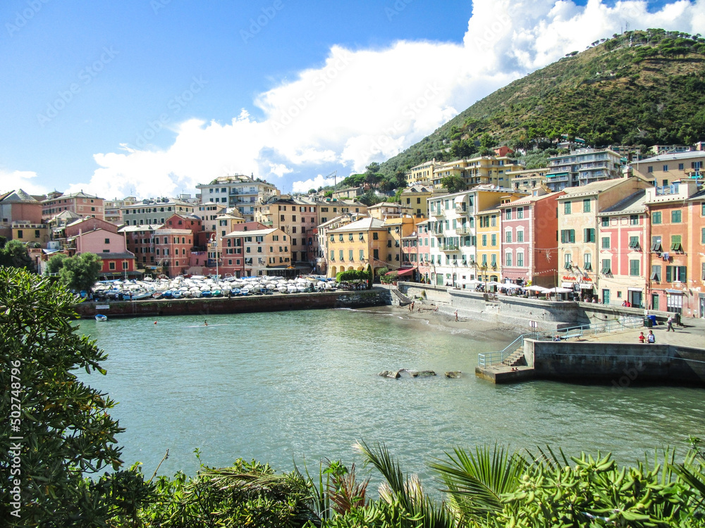 Port of Nervi in Genoa, Italy under a blue sky, surrounded by its colorful buildings