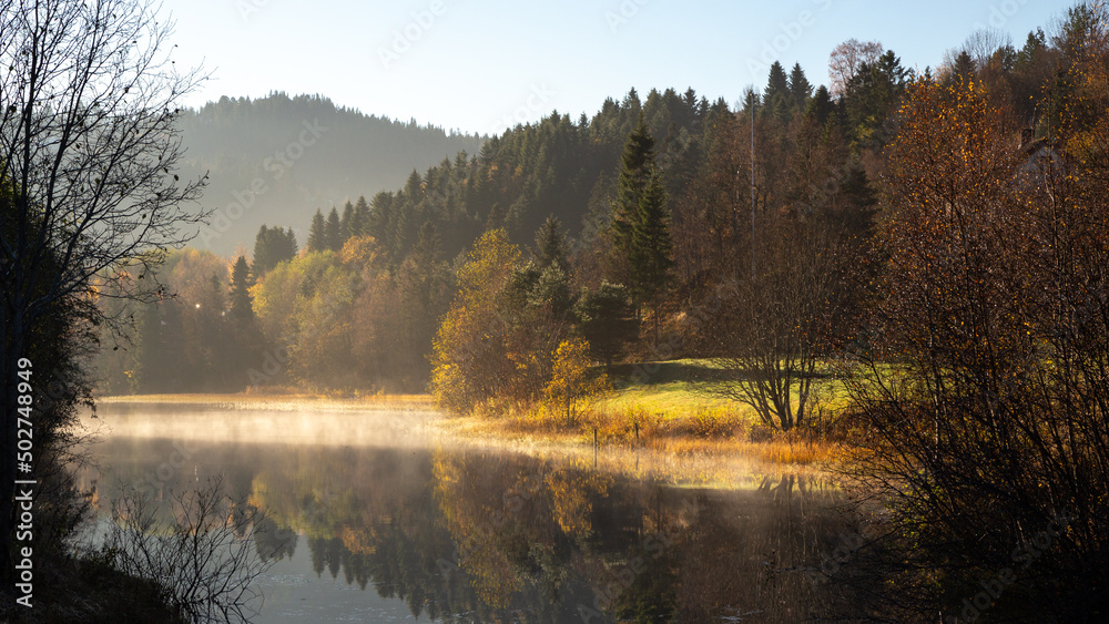 Fototapeta premium Misty and foggy autumnal morning by the calm lake