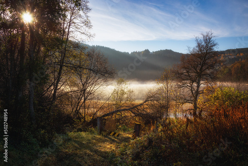 Misty and foggy autumnal morning by the calm lake