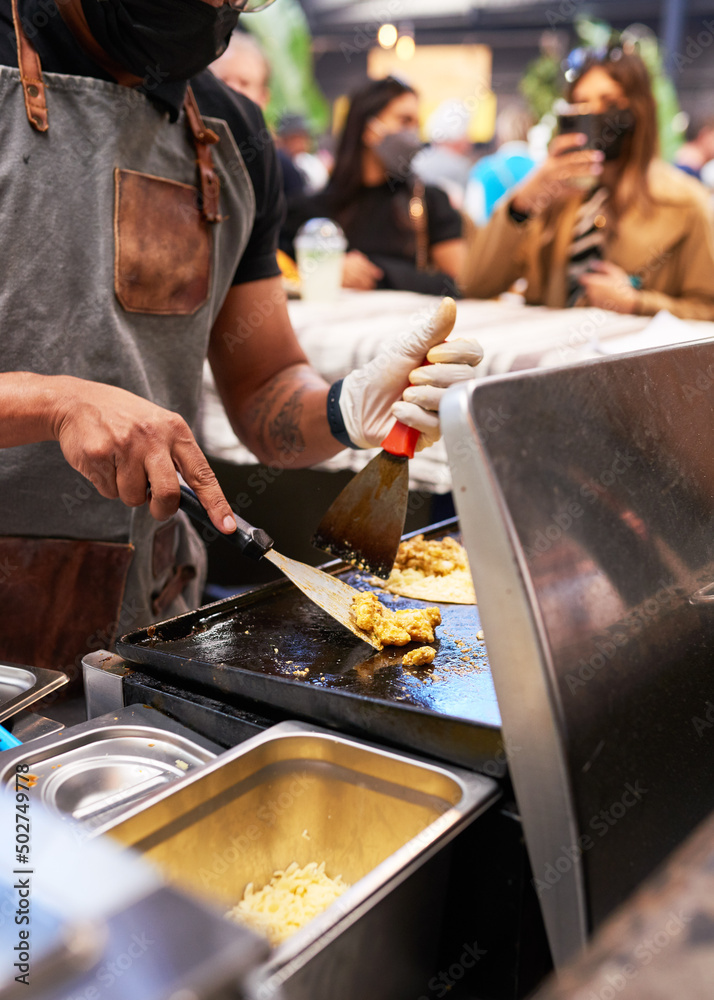 Close up shot of a chef cooking chicken for tacos at a food market