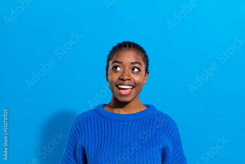 Portrait of attractive cheerful brunette bewildered girl fantasizing copy space isolated over vibrant blue color background