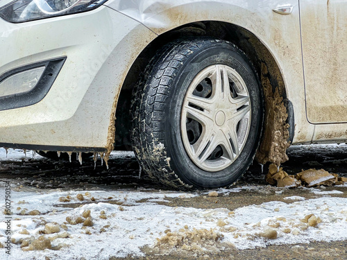 dirty snow on a car wheel in the wheel arch 