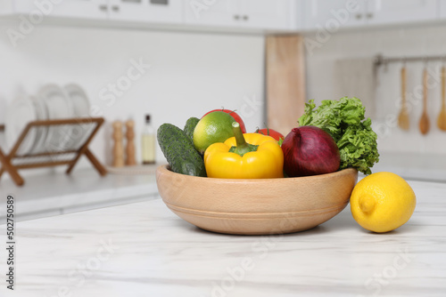 Fototapeta Naklejka Na Ścianę i Meble -  Bowl with fresh ripe vegetables and fruits on table in kitchen
