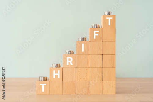 倹約・節約のイメージ｜「THRIFT」と書かれた積み木とコイン