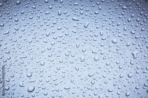 Abstract macro shot closeup of water drops on a metallic surface.