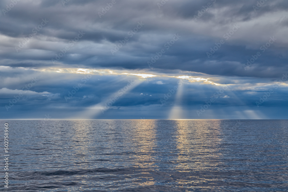 The sun's rays through a cloudy sky over the sea The sun's rays through a cloudy sky over the sea