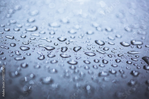 Abstract macro shot closeup of water drops on a metallic surface.