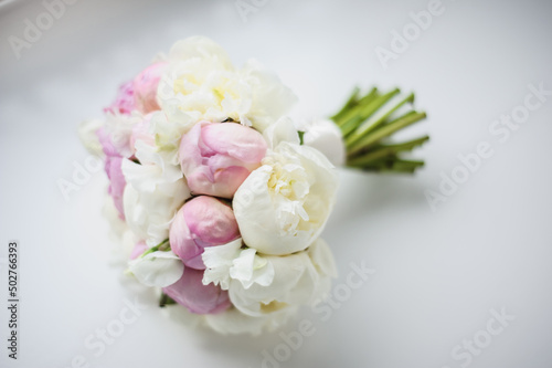 Wedding white flower bouquet for a bride on window background.