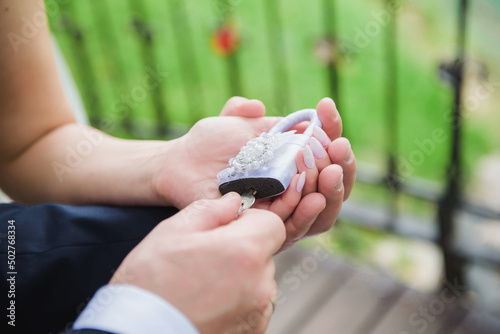 Bride and Groom Holding a Wedding Love Lock as a Symbol of Eternal Love. Popular wedding tradition symbolizes unity, unbreakable commitment. Concept of marriage, romance, and lasting partnership