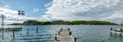 Bild auf Leinwand Steg an einem See in Schweden mit Schwedischer Flagge