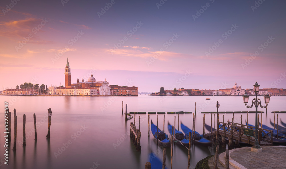 Naklejka premium Venice lagoon at sunrise, San Giorgio Maggiore church and gondolas. Italy, Europe. Long exposure photography.