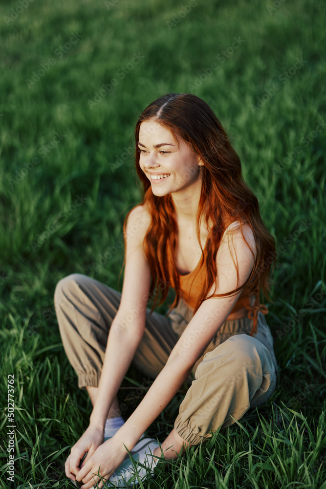 A young woman in summer clothes sitting on the green grass doing yoga and meditating in nature, a connection with the cosmos. The concept of harmony with body and nature, spiritual growth A young woman in summer clothes sitting on the green grass doing yoga and meditating in nature, a connection with the cosmos. The concept of harmony with body and nature, spiritual growth