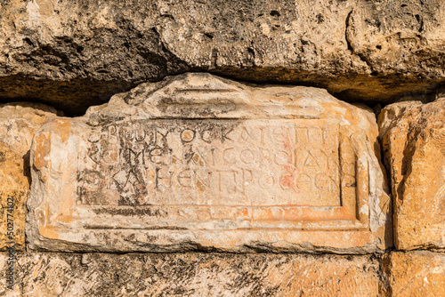 Ancient Greek symbols carved into a stone slab in the ancient city of Hierapolis. Pamukkale. Turkey. Close-up view.