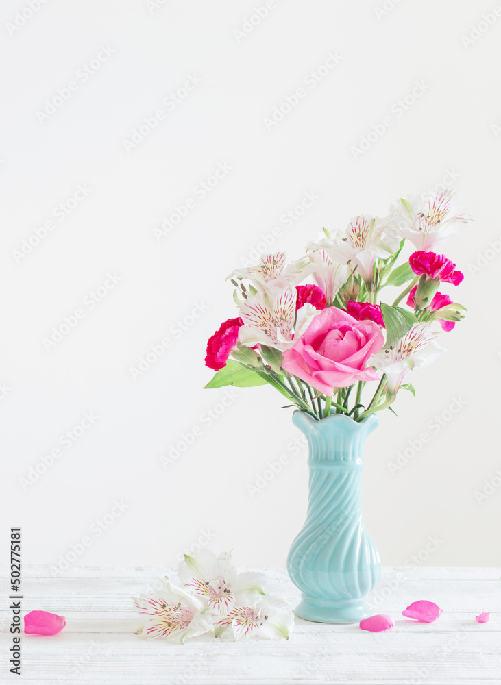 pink and white flowers in blue vase on white background foto de Stock |  Adobe Stock