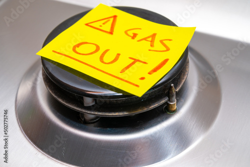 Gas stove turned off, with yellow note next to it with red text 