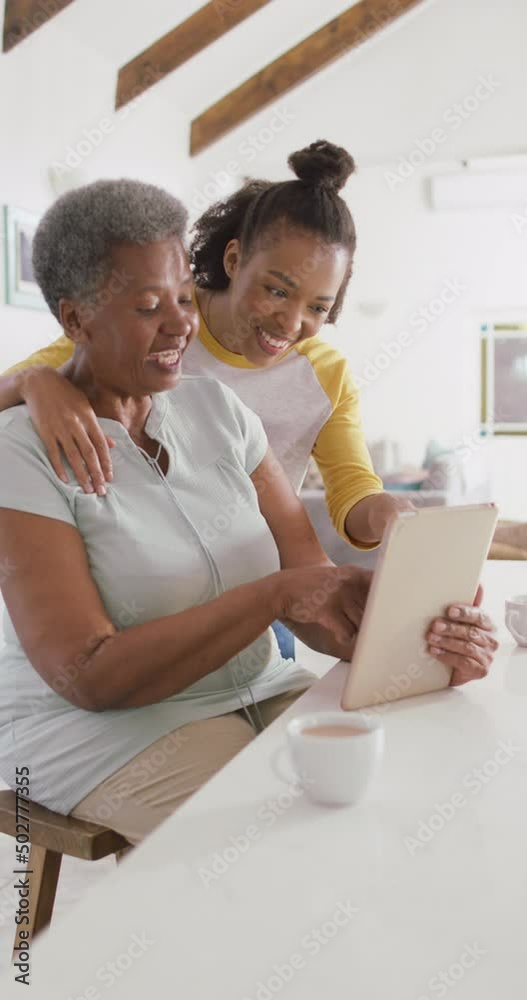 Vertical video of happy senior african american woman using tablet with adult daughter at home Vertical video of happy senior african american woman using tablet with adult daughter at home