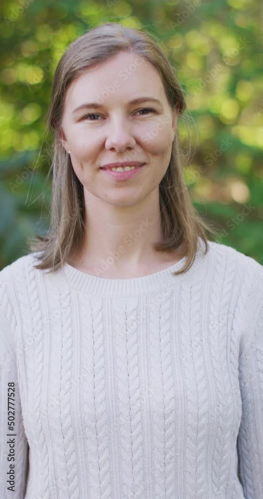 Vertical video of portrait of happy caucasian woman in garden Vertical video of portrait of happy caucasian woman in garden