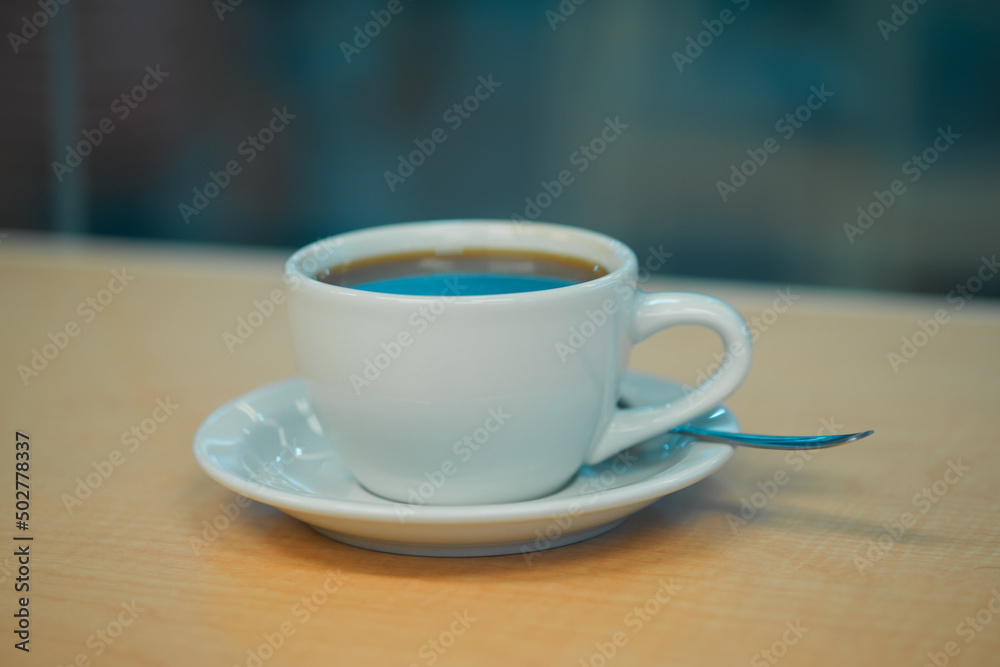 Coffee cup close up shot in a bar against a window on a wooden counter