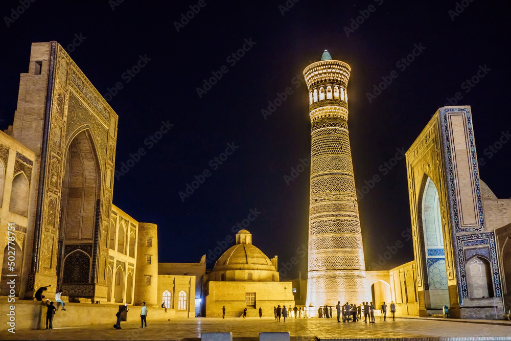 Obraz premium Night view of Po-i Kalyan architectural ensemble in Bukhara, Uzbekistan. Area between the buildings is a favorite place for locals and tourists for evening walks