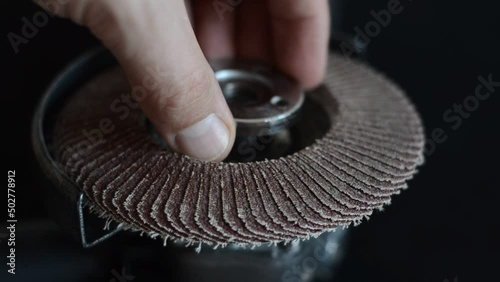 The master installs the cutting wheel in the angle grinder