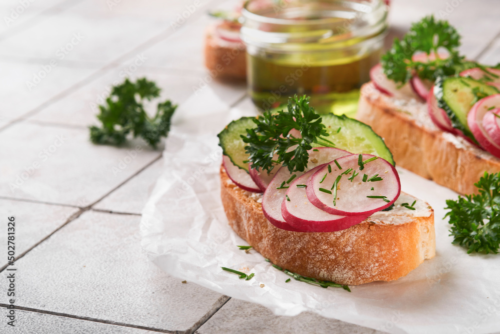 Toast with cheese and radish. Sandwiches with cottage cheese, radish, cucumber and green onions on old cracked tile background. Healthy spring sandwiches. Traditional Scandinavian toast. Top view.
