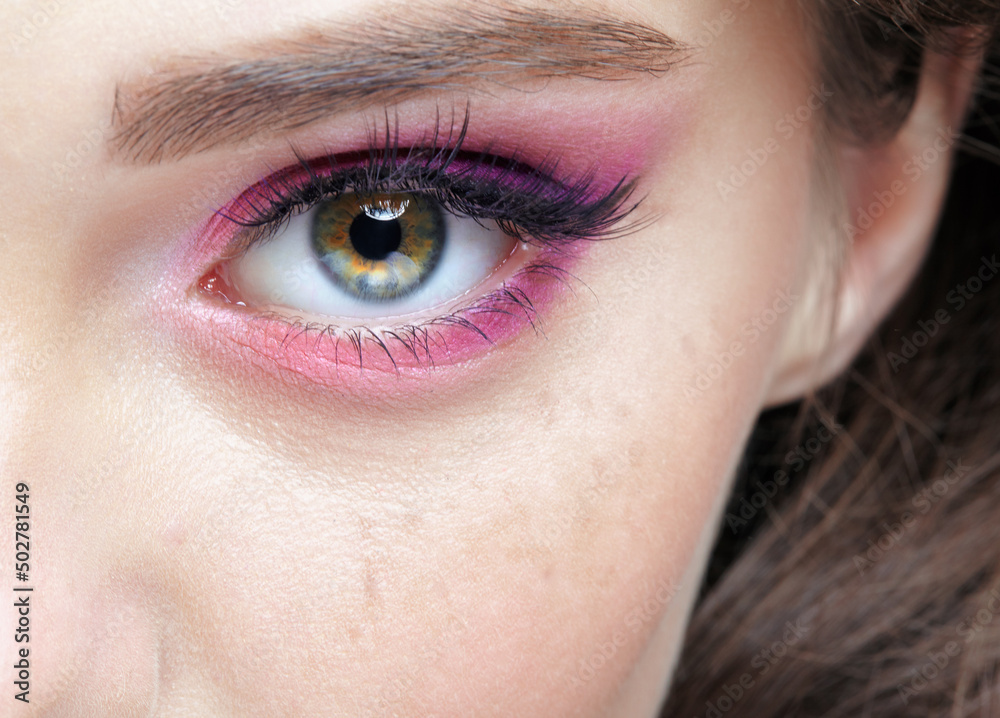 Fototapeta premium Closeup macro shot of human female eye with pink eyes shadows