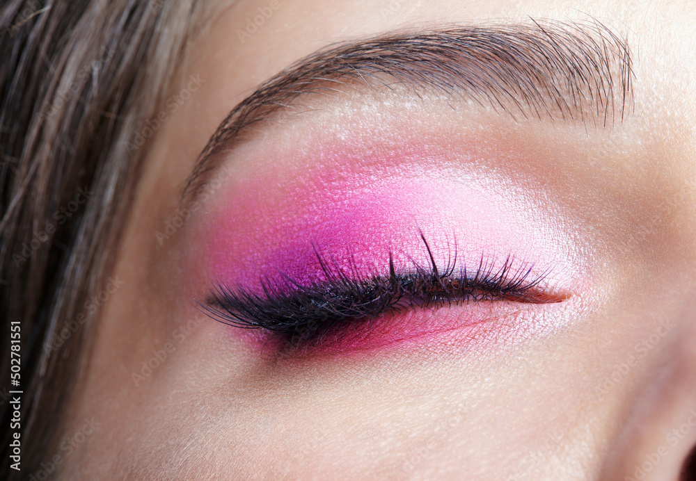 Naklejka premium Closeup macro shot of closed human female eye. Girl with perfect skin and pink eyes shadows