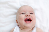 Infant laughing. Baby smiling with a toothless mouth close-up. Children healthcare