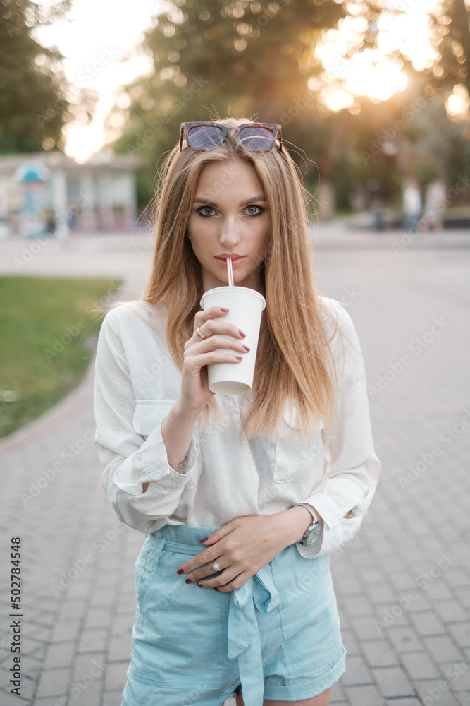 Nice woman in sunglasses drinking a milkshake Nice woman in sunglasses drinking a milkshake