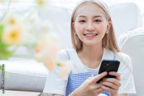 Young Asian girl using smartphone at home