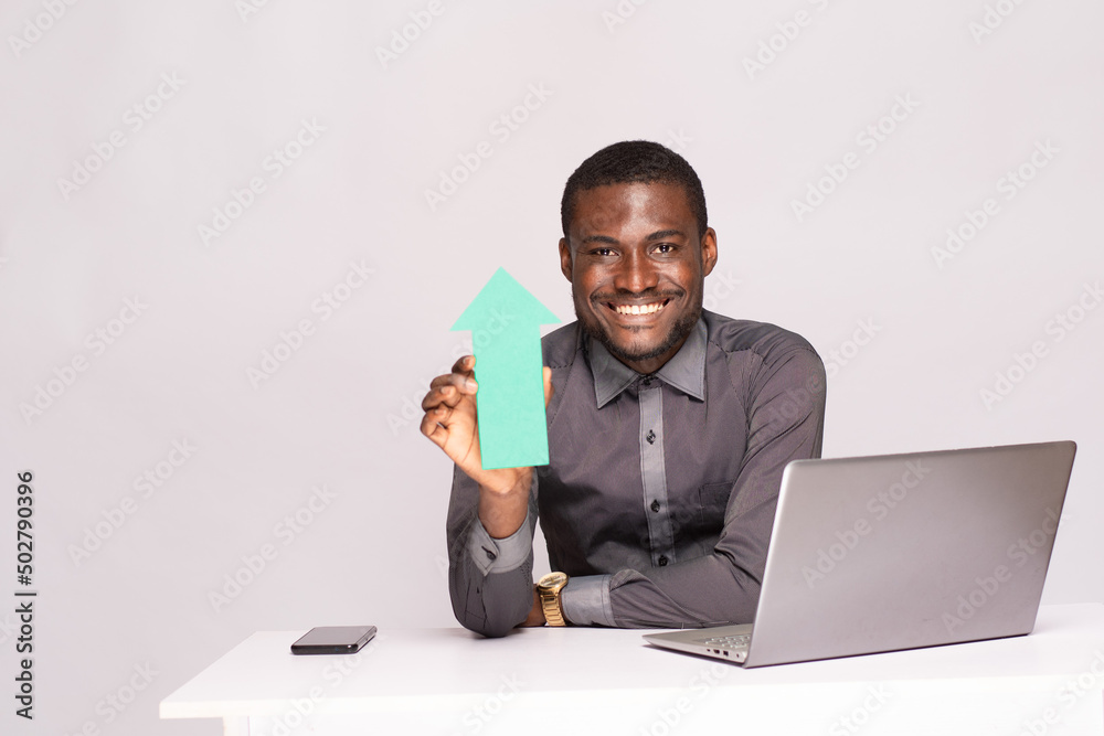 excited african businessman holding an arrow pointing upwards excited african businessman holding an arrow pointing upwards