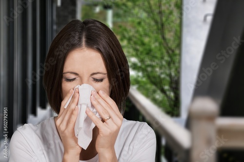 Allergy Season, girl blows in a napkin his nose on natural background